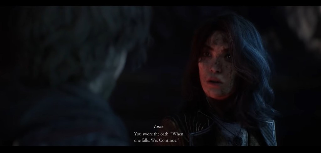 Night close-up shot of the back of Gustave's head as he faces Lune. Lune looks determined and gestures to emphasize her words. The campfire light highlights Lune's face.